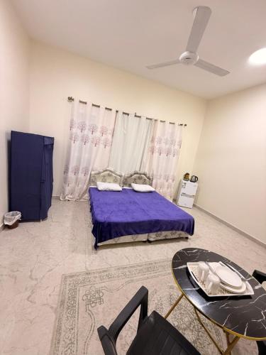 Mawāliḩmandegar guest house的一间卧室配有一张紫色的床和一张桌子