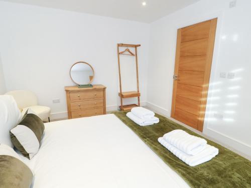 a bedroom with a bed with two towels on it at Glynllifon 4 in Llanallgo