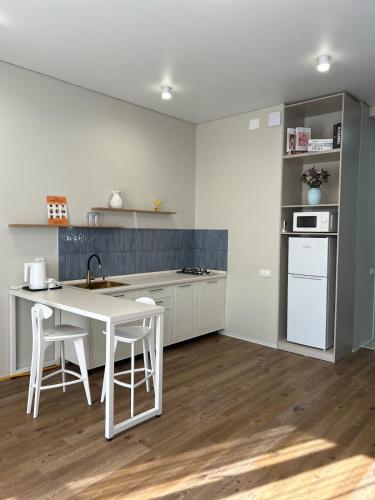 een keuken met een witte tafel en witte apparaten bij FLAT24 - Red in Zhezdi