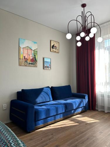 een blauwe bank in een woonkamer met een raam bij FLAT24 - Red in Zhezdi