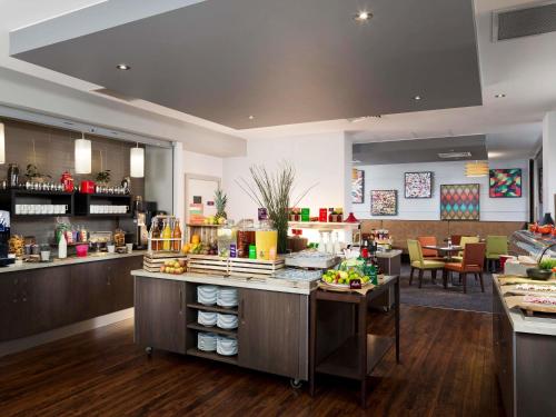 Un restaurante con un mostrador con comida. en Mercure Northampton, en Northampton