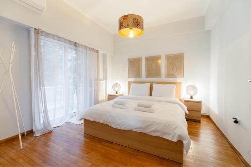 een slaapkamer met een groot bed en een groot raam bij Daphnes Home Chalkida Central in Chalkida