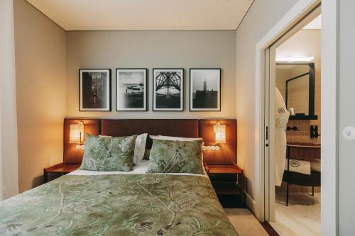 a bedroom with a bed with four pictures on the wall at Gran Cruz Apartments in Vila Nova de Gaia