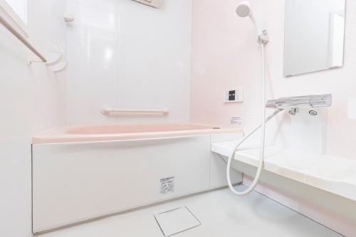 a white bathroom with a shower and a sink at Asakusa and Ueno Area, 2 Minutes to Iriya Station, Very Convenient in Tokyo