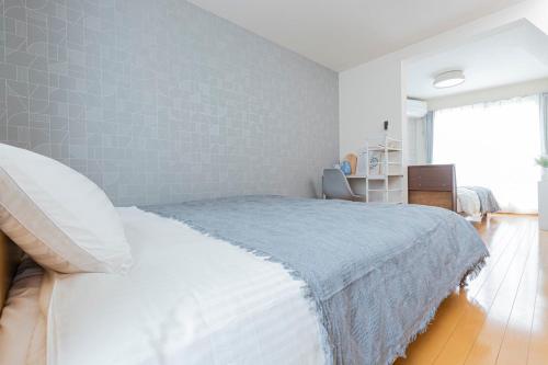 a bedroom with a white bed with a blue blanket at Asakusa and Ueno Area, 2 Minutes to Iriya Station, Very Convenient in Tokyo
