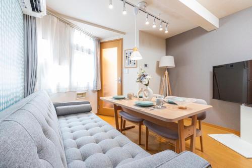 a living room with a couch and a table at Asakusa and Ueno Area, 2 Minutes to Iriya Station, Very Convenient in Tokyo