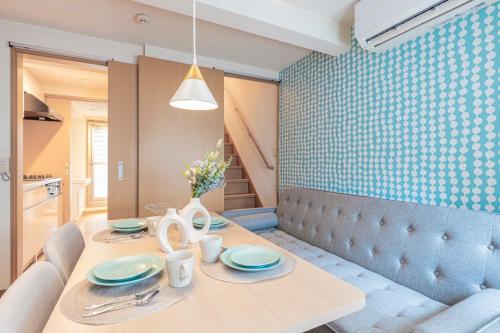 a dining room with a table with plates and utensils at Asakusa and Ueno Area, 2 Minutes to Iriya Station, Very Convenient in Tokyo