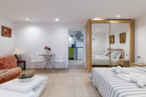 een hotelkamer met twee bedden en een woonkamer bij Studio indépendant en villa Calme, Jardins et Piscine à 5 min de la Mer in Nice