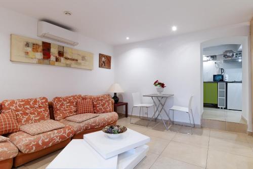 een woonkamer met een bank en een tafel bij Studio indépendant en villa Calme, Jardins et Piscine à 5 min de la Mer in Nice