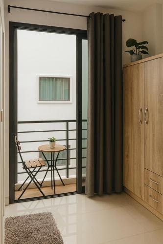 a room with a balcony with a table and a glass door at CİMELi Guest House in Patong Beach