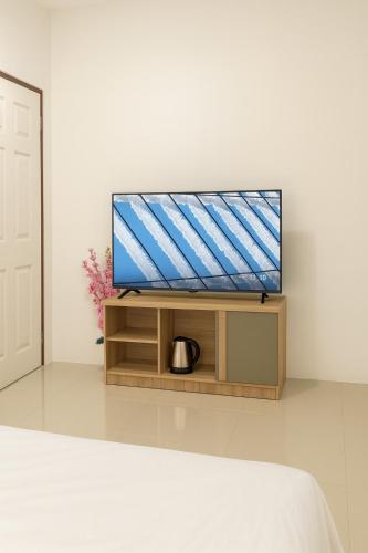 a flat screen tv sitting on a stand in a room at CİMELi Guest House in Patong Beach