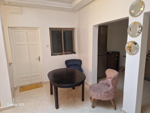 een kamer met een tafel en twee stoelen en een klok bij bedroom double bed private bathroom in Agadir