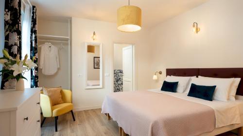 een slaapkamer met een groot bed en een gele stoel bij VILLA FRANCESCA 10, Emma Villas in Volterra