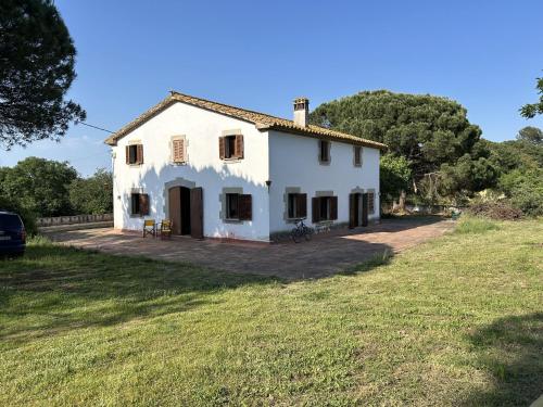 ein weißes Haus auf einem Feld mit einem Auto in der Unterkunft FRANCIAC Casanova in Franciach