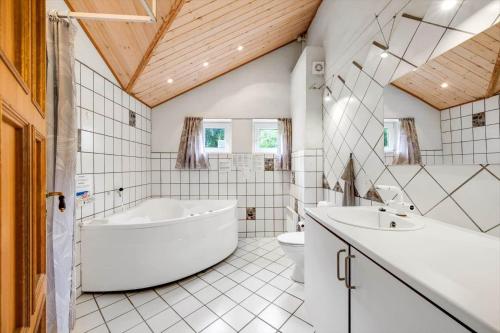 a bathroom with a tub and a sink and a toilet at 20832-Tim-Alrum-1 in Alrum