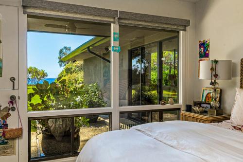 una camera da letto con una grande finestra che si affaccia sull'oceano di Fernald Point Adventure a Montecito
