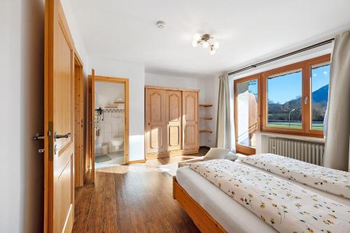 a bedroom with two beds and a large window at Wohnung Hochfelln in Ruhpolding