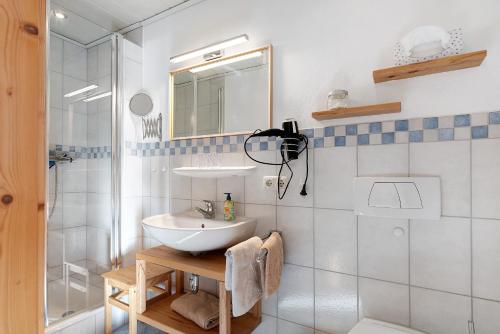 a white bathroom with a sink and a shower at Wohnung Hochfelln in Ruhpolding