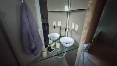 a bathroom with two white toilets and a glass table at Flat mobiliado e bem localizado in Recife