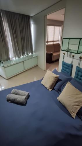 una camera da letto con un grande letto blu con due cuscini di Flat mobiliado e bem localizado a Recife