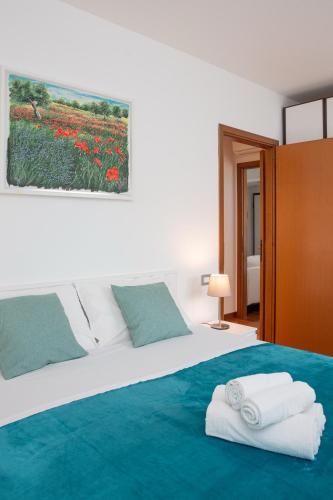 a bedroom with a large bed with towels on it at ArtStay Apt near Rho Fiera, Pool, Parking in Settimo Milanese