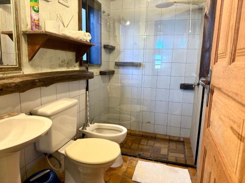 un baño con inodoro y lavabo en Pousada Uhuru, en Praia do Rosa