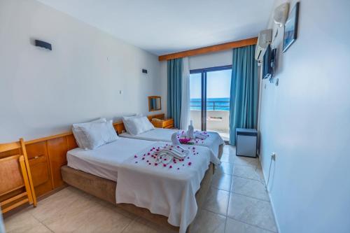 una camera da letto con un letto e un tavolo con dei fiori sopra di Çidihan HOTEL a Kusadası
