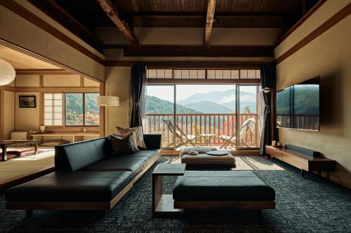 a living room with a couch and a large window at 千日箱根 SEN-NICHI Hakone 大涌谷を望む絶景宿 in Hakone