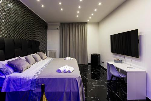 ein Schlafzimmer mit Bett, Schreibtisch und Fernseher in der Unterkunft Scio' Scio' in Neapel