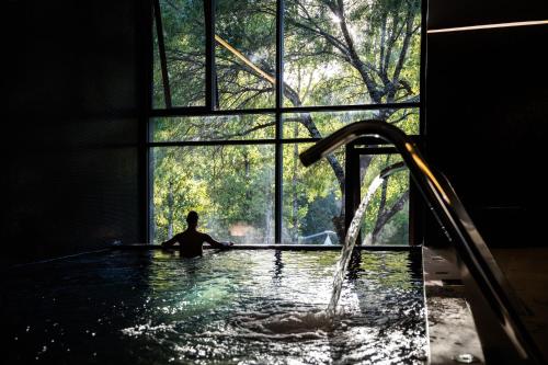 a man in a bath tub with a window at Aqua Village, Health Resort in Oliveira do Hospital