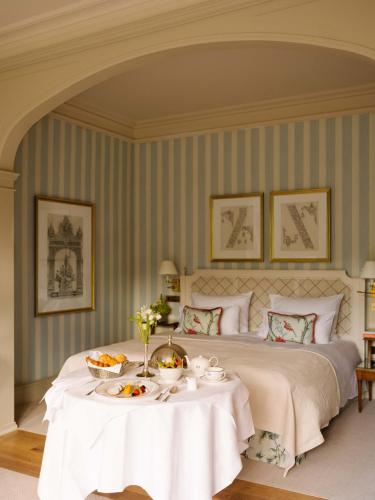 Un dormitorio con una cama con una mesa con comida. en Brenners Park Hotel & Spa, Oetker Hotels, en Baden-Baden