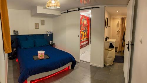 Un dormitorio con una cama azul y una bandeja. en Cinema & Netflix a La Roche, en La Roche-sur-Yon