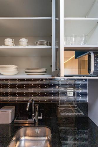 una cucina con un lavello e uno scaffale con i piatti di Edifício White 2880 | Rebouças/Faria Lima a San Paolo