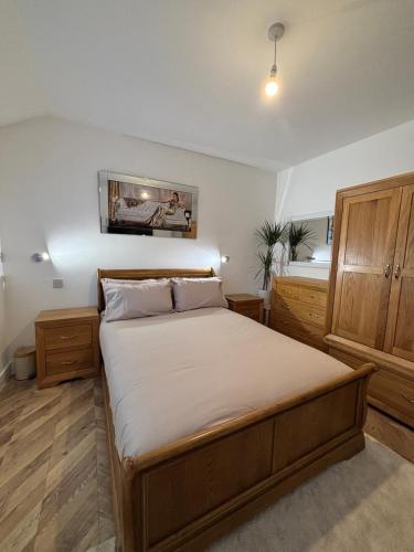 een slaapkamer met een groot bed en houten kasten bij Hendham Lodge in Manchester