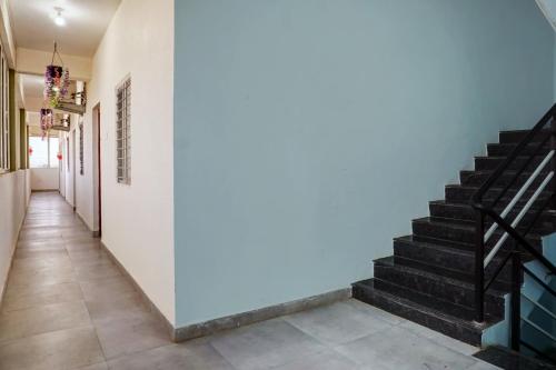 un corridoio con scale e parete blu di Hotel O Royal Inn a Dehu