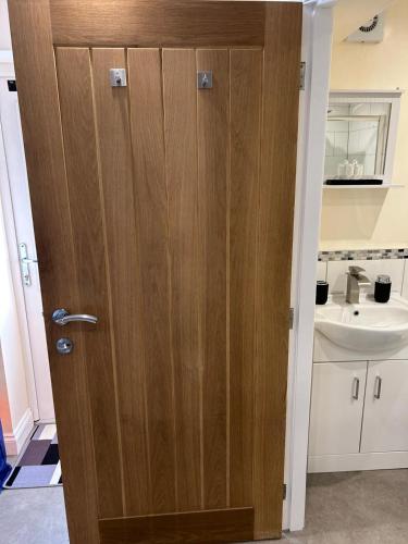 a wooden door in a bathroom with a sink at Studio 1 in Howden