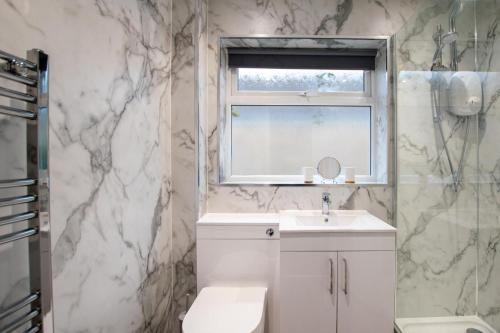 een badkamer met een witte wastafel en een raam bij 2 Bed in Kings Lynn oc-chln8 in Heacham