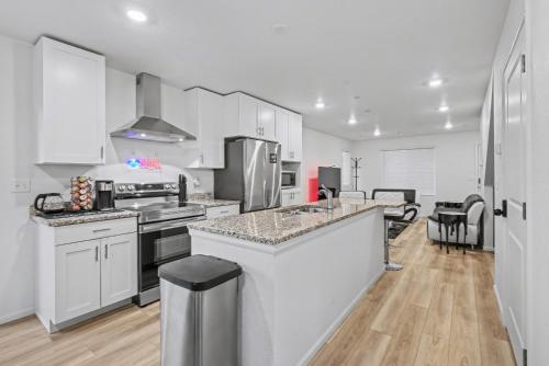 een keuken met witte kasten en roestvrijstalen apparaten bij Modern 2BR 2BA Townhome 15 Min to DEN in Commerce City
