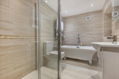 een badkamer met een bad, een toilet en een wastafel bij 2 Bed in Fowey oc-r30265 in Fowey