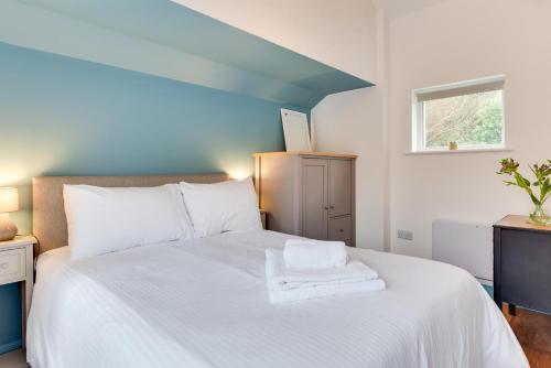 a bedroom with a bed with white sheets and a window at 1 Bed in Duloe oc-l30057 in Duloe