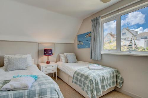 a bedroom with two beds and a window at 3 Bed in Fowey oc-tidewa in Fowey