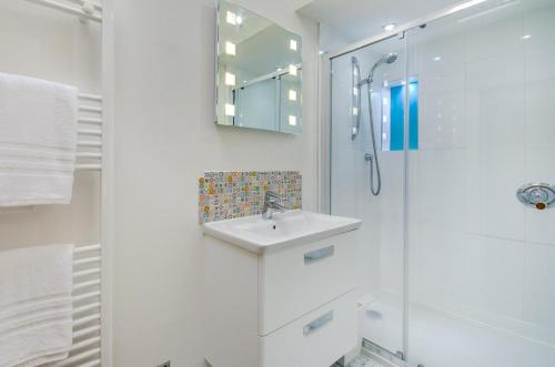 ein weißes Badezimmer mit Waschbecken und Dusche in der Unterkunft 2 Bed in Fowey oc-p00873 in Fowey