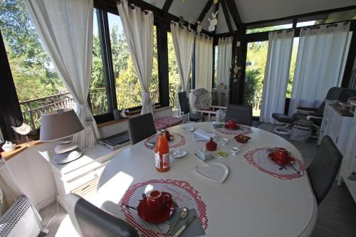 een eetkamer met een witte tafel en stoelen bij La Roulotte d'Arthur in Sercoeur