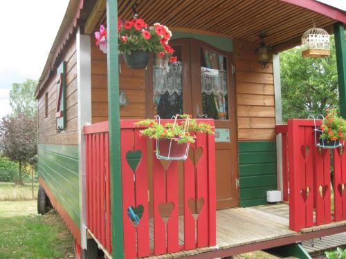 a house with flower pots on the front of it at La Roulotte d'Arthur in Sercoeur