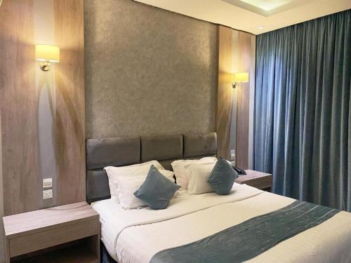a bedroom with a large bed with blue pillows at فندق ليان بارك Lian Park Hotel in Al Khobar
