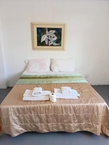 a bed with two towels and two rolls of towels at Hotel BH Center in Belo Horizonte
