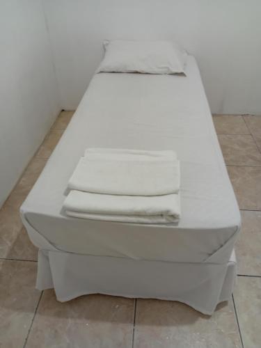 a white bed with two folded towels on it at Hotel BH Center in Belo Horizonte