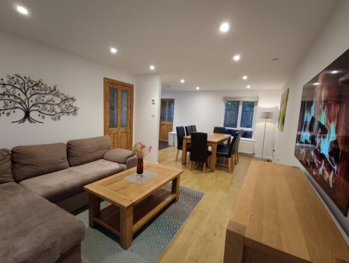 a living room with a couch and a table at 3 Bedroom house, Smart TV, PARKING 3 cars, GARDEN, Wi-fi, CONTRACTOR STAY, close to the Beach, Shops, Hospital, Airport in Bournemouth