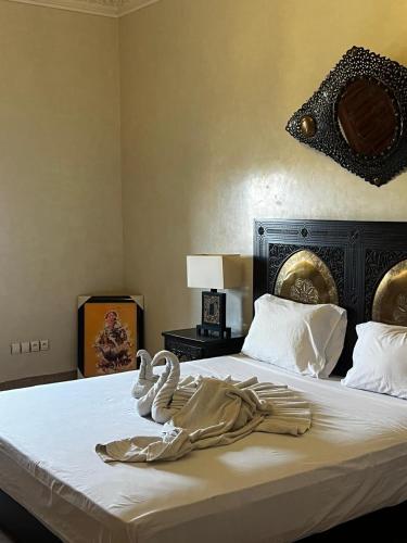 a bed with two swans towels sitting on it at Villa Oum Palace in Marrakesh