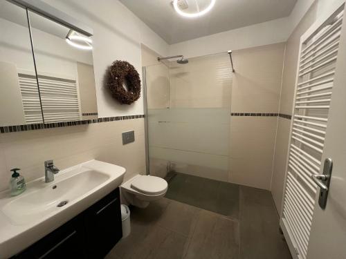 une salle de bains avec lavabo, toilettes et douche dans l'établissement Mühlenblick, à Brunshaupten